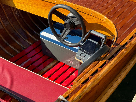 Varnished wooden Canadian Challenger runabout at the dock, red upholstery and helm