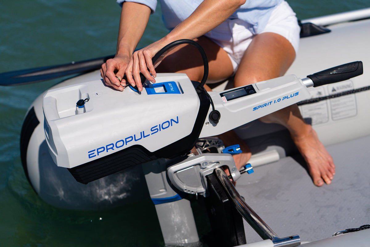 Boater operating the tiller and display on an ePropulsion Spirit 1.0 Plus electric outboard mounted to an inflatable
