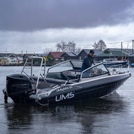 A man navigating the UMS 655 DC aluminum boat.