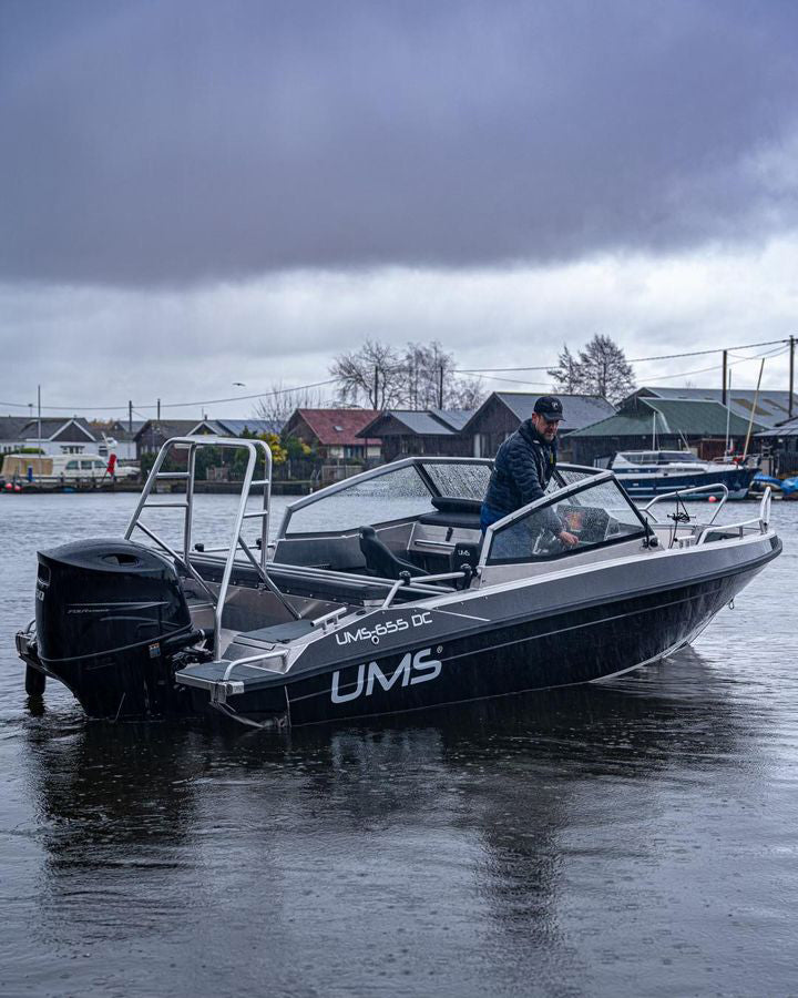 A man navigating the UMS 655 DC aluminum boat.