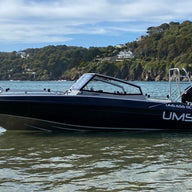 A side view of the UMS 655 DC aluminum boat anchored in shallow water.
