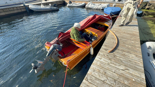 Rigging the Momentum M10 electric outboard on the Canadian Challenger at a marina dock