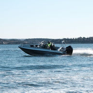 An aluminum boat UMS 655DC 21ft cruising on open water.