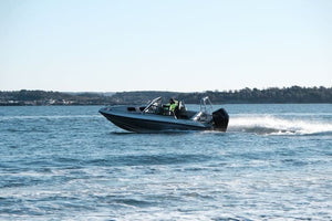 An aluminum boat UMS 655DC 21ft cruising on open water.