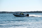 An aluminum boat UMS 655DC 21ft cruising on open water.