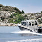 The UMS 865CAB aluminum boat cruising along a rocky shoreline.