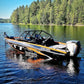 An aluminum UMS 585DC fishing boat with a sleek design floats on a calm lake.