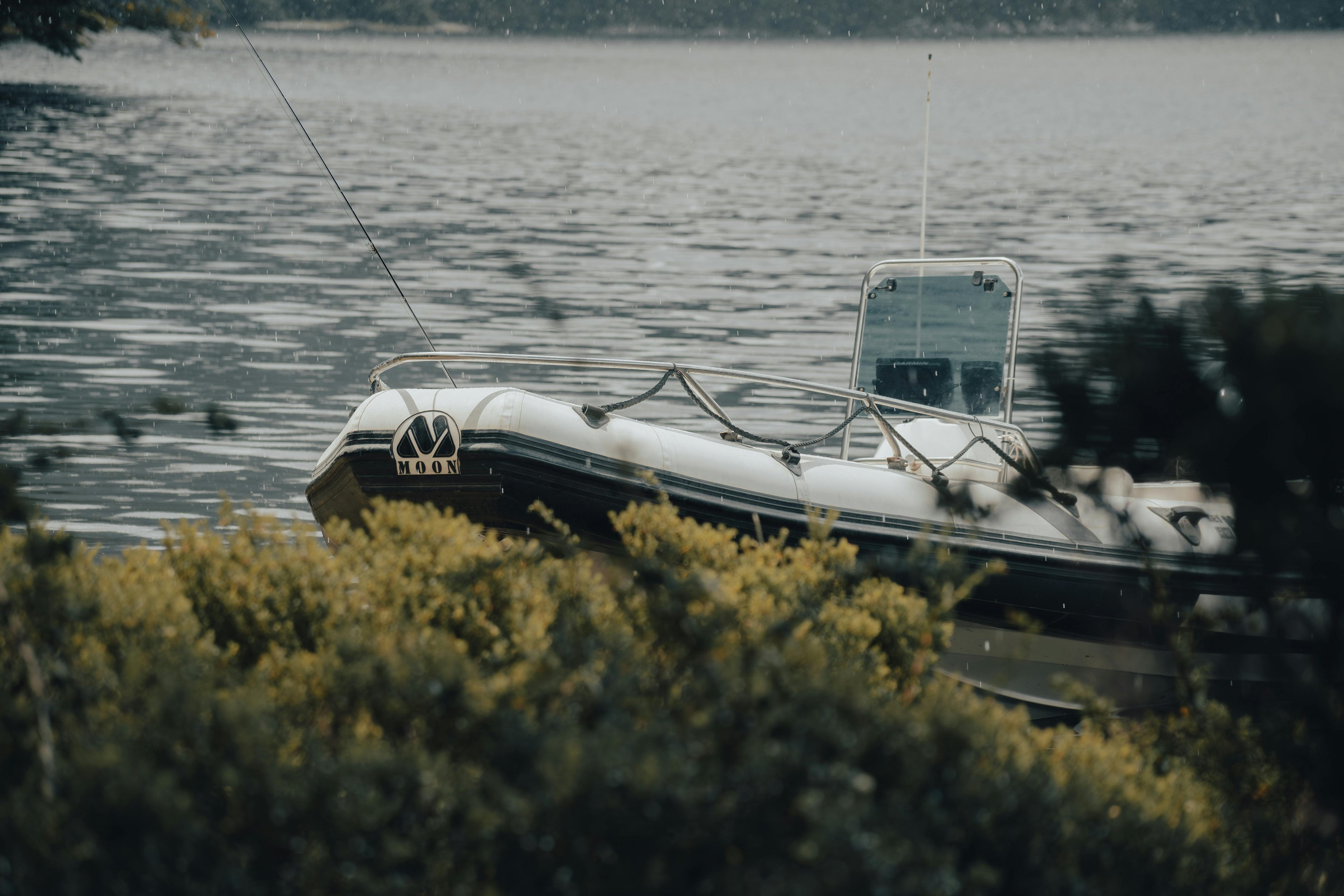 Inflatable boat on a lake with trees in the foreground