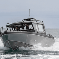The UMS 700HT aluminum boat cutting through the waves head-on.