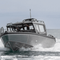 The UMS 700HT aluminum boat cutting through the waves head-on.