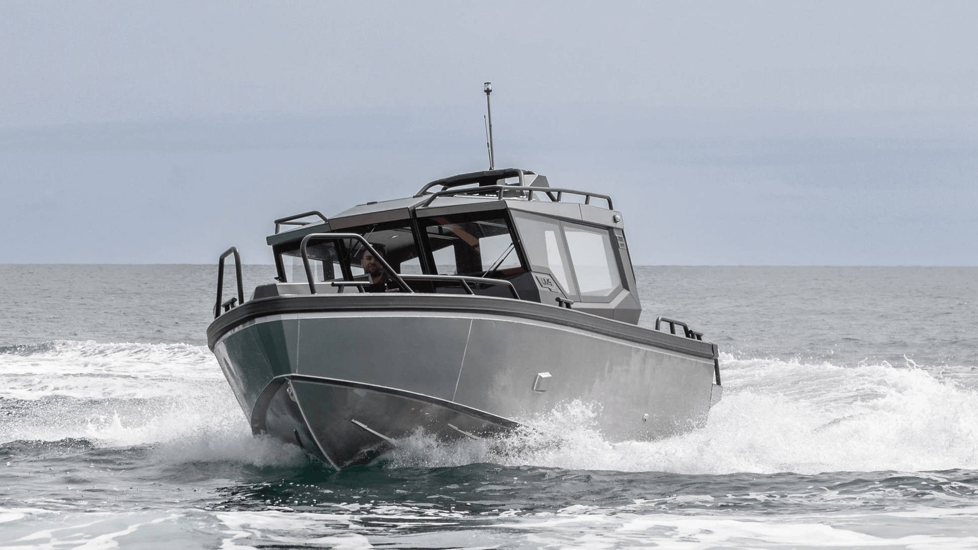 The UMS 700HT aluminum boat cutting through the waves head-on.