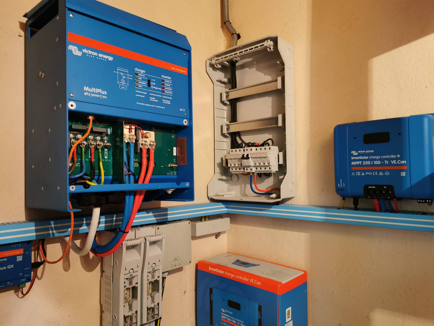 Electrical panel with various components and wiring on a beige wall.